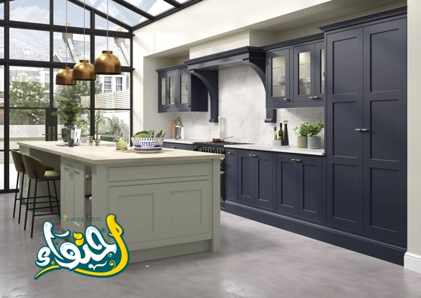 خزائن مطبخ باللون الأزرق الداكن وألواح رخامية وجزيرة خضراء اللون مع نوافذ وأبواب كريتال